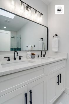 a bathroom with two sinks and a large mirror over it's top cabinetry