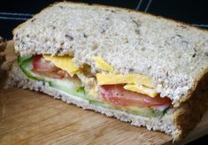 a sandwich cut in half sitting on top of a wooden cutting board