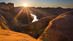 the sun shines brightly over rocks and water in an area that looks like desert land