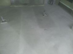 two birds are standing in the middle of a room with concrete floors and no walls