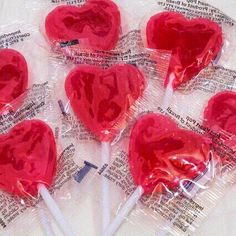 four heart shaped lollipops wrapped in plastic wrappers