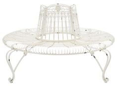 a white metal birdcage sitting on top of a table next to a chair