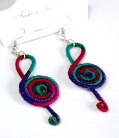 a pair of earrings with colorful thread and beads hanging from it's earwires