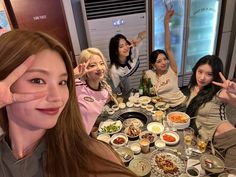 a group of women sitting around a table with food