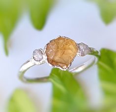 CUT-OFF DATE TO RECEIVE YOUR ORDER BY CHRISTMAS: Sunday December 10th, 2023 All orders received AFTER December 10th will be created and shipped after the Christmas Holidays. Nature lovers will swoon over this stunning Raw Citrine and diamond engagement ring ! Set on a uniquely crafted Sterling Silver band, a beautiful natural raw Citrine is nestled between 2 sparkly raw diamonds - making this a one-of-a-kind November birthstone ring, a unique promise ring or a lovely raw stone alternative engage Elegant Raw Stone Gift Rings, Raw Citrine Ring, Elegant Rings With Raw Stone, Round Shape, Raw Crystal Engagement Rings By Angeline, Bohemian Style Raw Stone Crystal Ring, Christmas Nature, Rough Diamond Engagement Ring, Rough Gemstone Ring, November Birthstone Ring