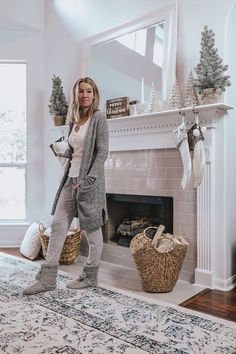 a woman standing in front of a fireplace with her feet on the fire place and holding a basket