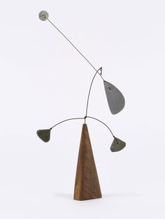 a sculpture made out of metal and wood with three lights hanging from it's sides