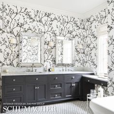 a bathroom with black and white wallpaper, two sinks and mirrors on the wall