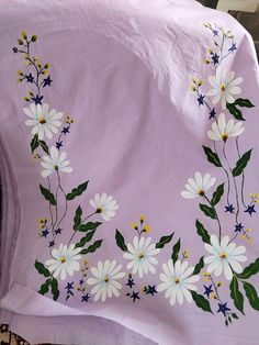 a blanket with white flowers and green leaves on it