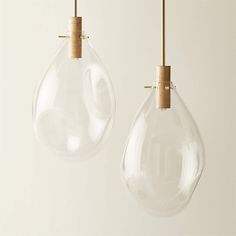 two clear glass lamps hanging from wooden cords