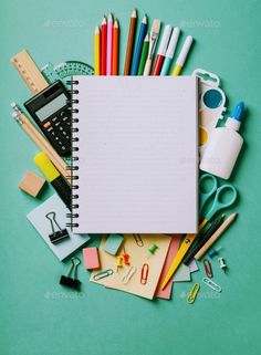 an open notebook surrounded by school supplies on a green background - stock photo - images