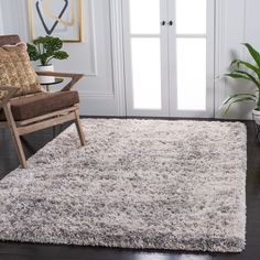 a living room area with a chair and rug on the hardwood floor next to a door