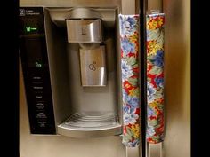 a stainless steel refrigerator with a floral towel hanging from it's door and a water dispenser on the side