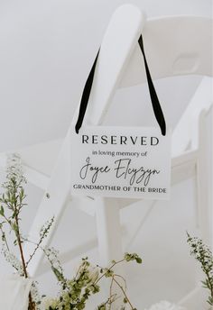 a white chair with a sign hanging from it's back that says reserved to loving memory of grace blogger grandmother of the bride