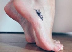 a woman's foot with a small triangle tattoo on the bottom of her ankle