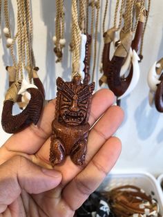 a person holding some kind of wooden animal ornament in their hand with other ornaments hanging from the wall behind them