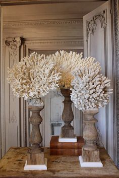 two vases filled with white flowers on top of a table