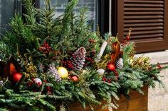 a window box filled with christmas decorations and pine cones