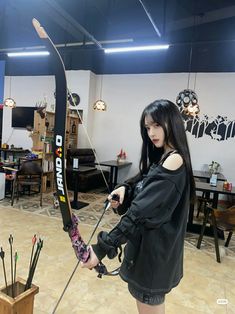 a woman holding a bow and arrow in a room