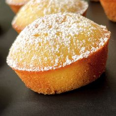 several pastries with powdered sugar on them sitting on a table top, ready to be eaten