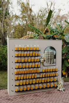 there is a large display with many cups on it in front of some trees and bushes