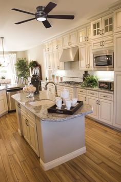 a kitchen with white cabinets and wood floors is featured in the article diy painted cabinets