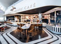 the interior of a restaurant with black and white tile flooring, tables and chairs