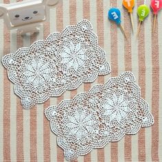 two white doily sitting on top of a table next to cake candles and toys