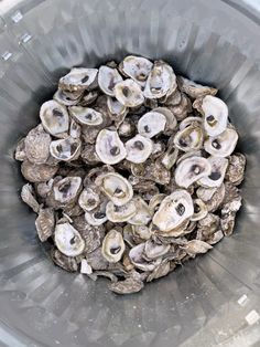 a bucket filled with oysters sitting on top of a table