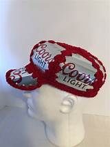 a white mannequin head wearing a coca - cola light hat with crochet