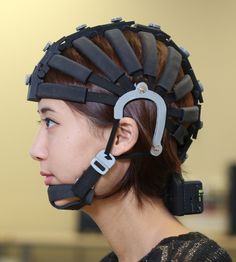 a woman with an unusual head piece made out of black plastic and metal clips on it's back