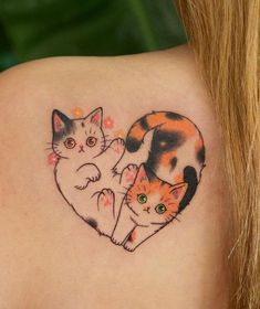 two cats in the shape of a heart tattoo on the back of a woman's shoulder