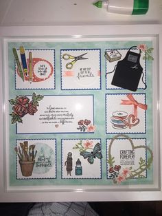 a white frame with some pictures on it and scissors, flowers and other things in it