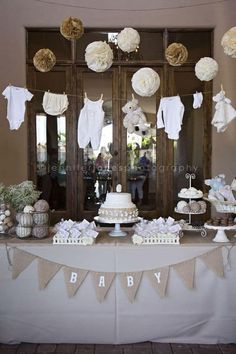 a baby shower table with cake and decorations