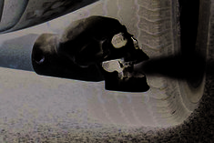 a silver skull head on the side of a car's front bumper and tire