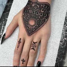 a woman's hand with some tattoos on it