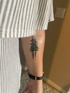 a person with a pine tree tattoo on their arm