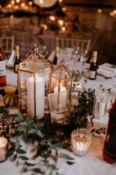 a table with candles and greenery on it