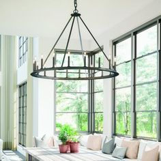 a living room with couches, windows and a chandelier hanging from the ceiling