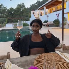 a woman sitting at a table with a glass of wine