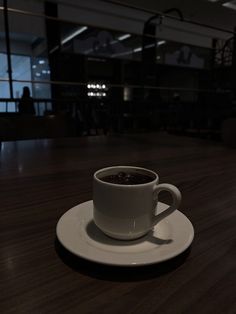 a cup of coffee sitting on top of a white saucer