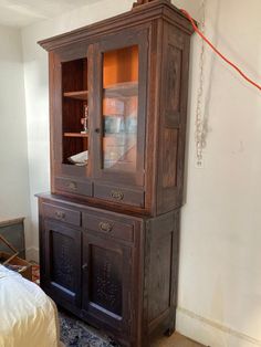 an old wooden china cabinet with glass doors