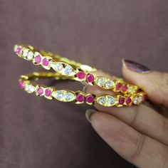 "* Bangles with high quality CZ stones. * High Quality 22K Gold Plated. Bangles Sizes : 2.4 inches= ( 2.32\" diameter of the inner circle) ; 2.6 inches = ( 2.42\" diameter of the inner circle); 2.8inches = (2.54\" diameter of the inner circle) The gorgeous gold-plated bangles set best exemplifies the careful craftsmanship done on it -- specially picked for you by Nemali Jewelry. It has a special tone of elegance attached to it. The intricate handmade design of the bangle/bracelet set gives it a Pink Ruby Round Bracelets, Festive Round Bangle With Stone Setting, Festive Ruby Round Bangle, Festive Round Ruby Bangle, Jeweled Round Bangle For Anniversary, Festive Pink Bangle With Stone Work, Festive American Diamond Round Bangle, Round Stone Work Bangle For Celebration, Bollywood Style Jeweled Round Bangle