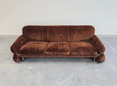 a brown couch sitting on top of a cement floor