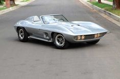 a silver sports car is parked on the street