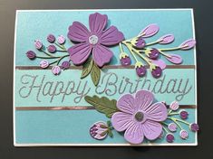 a birthday card with purple flowers and green leaves