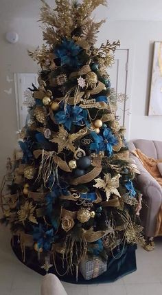 a blue and gold christmas tree in a living room