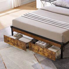 a bed with two drawers underneath it on the floor next to a table and chair