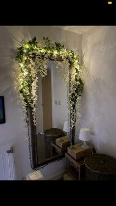 there is a mirror that has flowers on it and lights in the room behind it