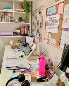 a cluttered desk in an office with lots of books and papers on the shelves